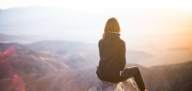 image : femme assise sur le sommet d'uune montagne - Chemin d'Âme Nature