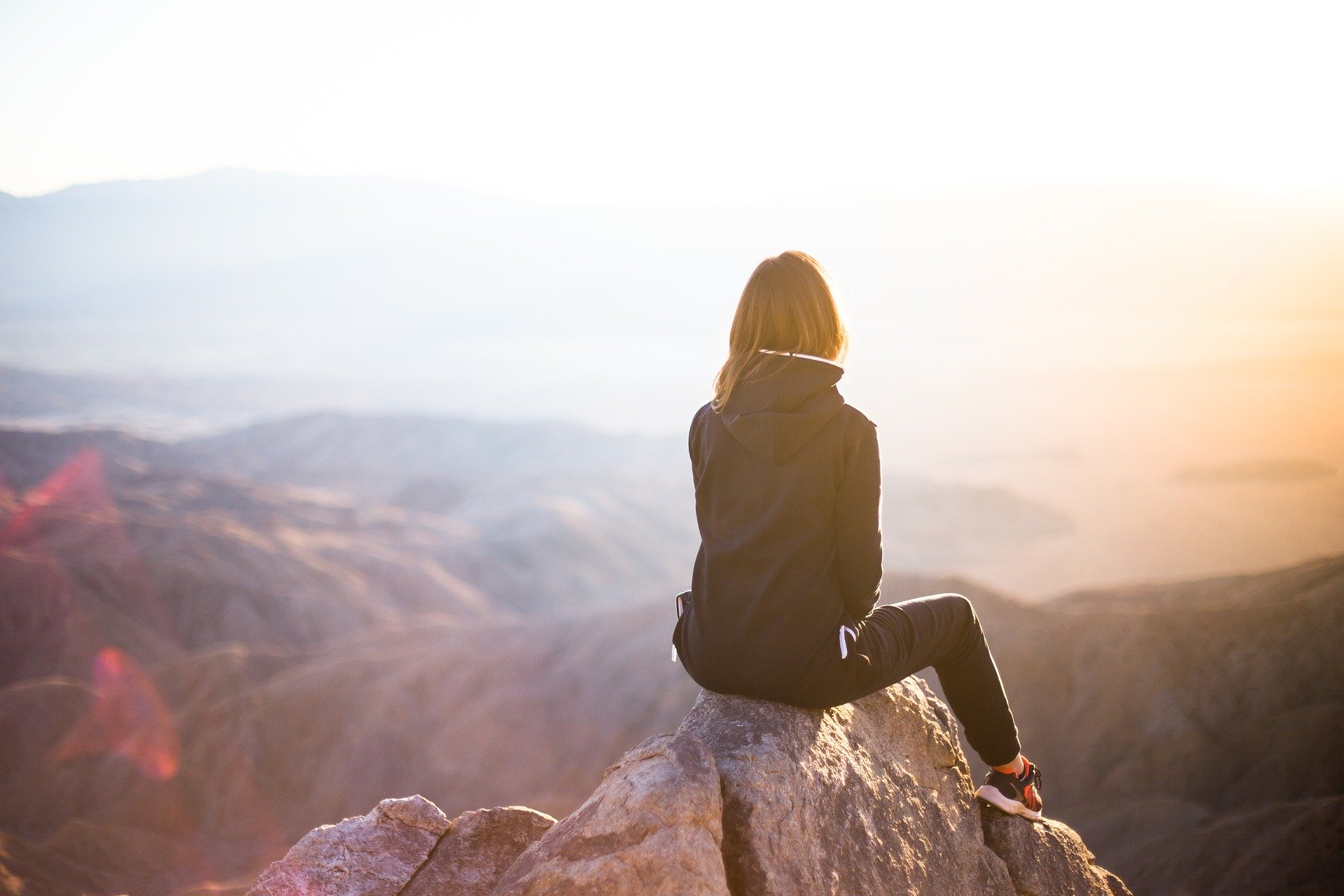image : femme assise sur le sommet d'uune montagne - Chemin d'Âme Nature
