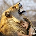 Une fille heureuse câline un lion