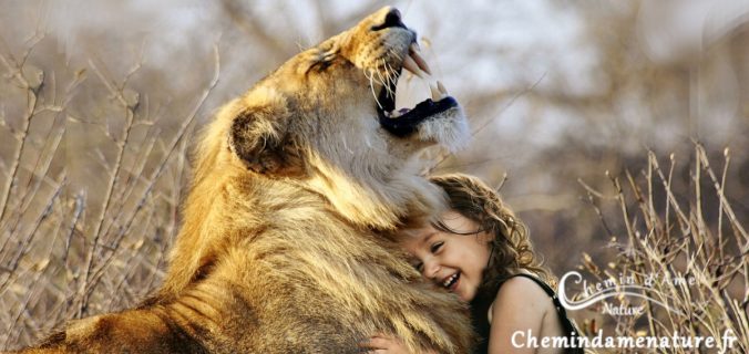 Une fille heureuse câline un lion
